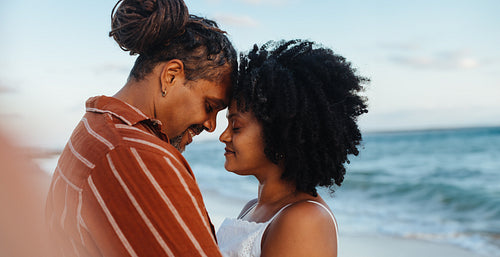 Authentic couple in love sharing an intimate moment on the beach