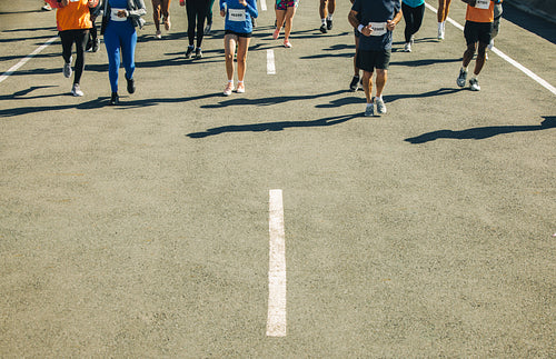 Runners competing in an outdoor marathon event on sunny day