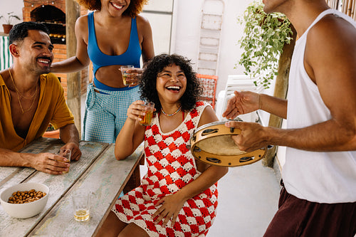 Group of friends celebrating with music and drinks in a festive setting