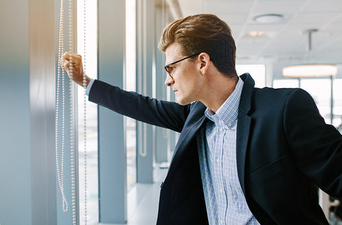Mature businessman looking outside the office window