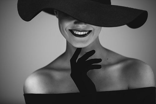 Elegant beautiful woman in a black dress and hat