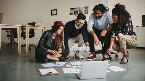 Business partners working as a team discussing work sitting on the floor