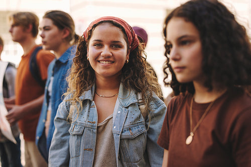 Happy teenage girl protesting with a group of demonstrators in the city