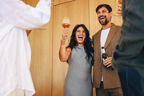 Couple toasting with friends during a celebration at a modern home