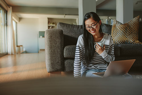 Woman sitting on floor laptop and coffee
