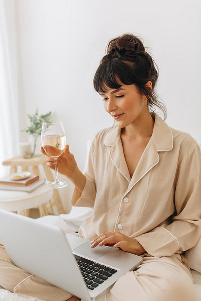 Woman working from home holding a wine glass