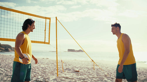 Medium shot of two beach volleyball players celebrating their victory