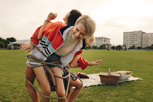 Cheerful friends having fun being tangled in a rope