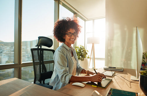 Creative woman working in office with graphic tablet