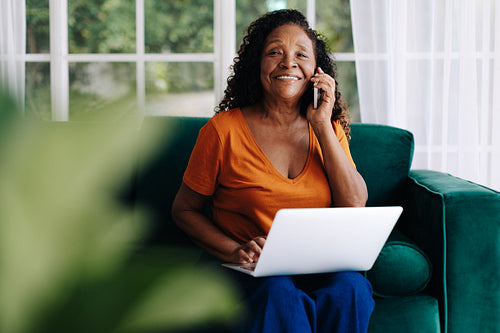 Working from home: Senior woman making a business call from her home office