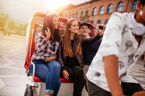 Young friends taking selfie on tricycle ride