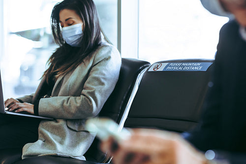 Businesswoman working on laptop at airport terminal