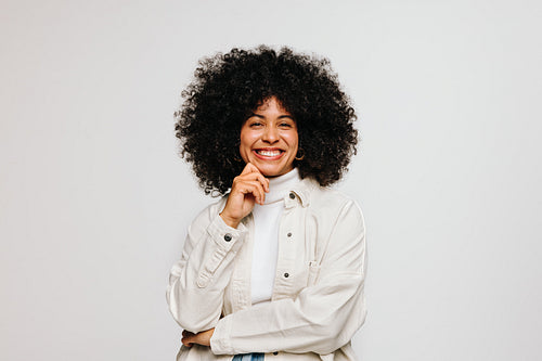 Gorgeous woman with Afro hair smiling happily in a studio