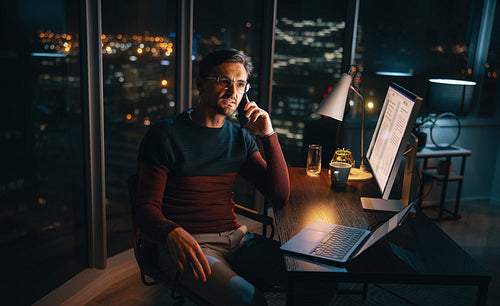 Late-night work calls: Businessman balances home office and work tasks