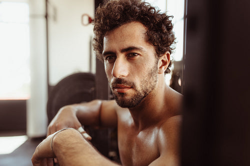 Male taking rest after intense training in gym