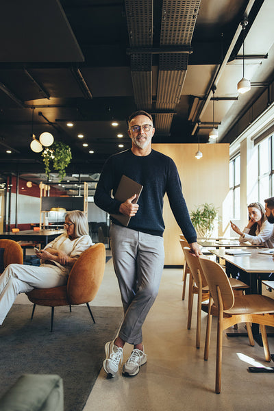 Experienced businessman standing in a co-working space