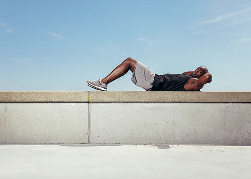 Muscular young man doing sit-ups
