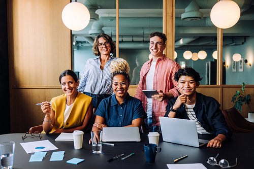 Group of professionals smiling and working together in an office setting
