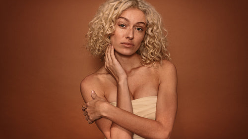 Woman standing against brown background