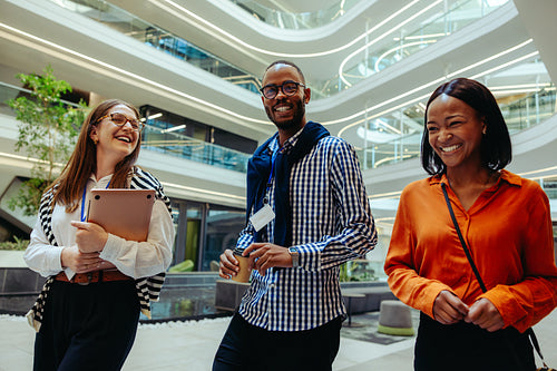 Cheerful colleagues walking together in a modern corporate setting