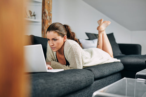 Young woman busy using a laptop at home