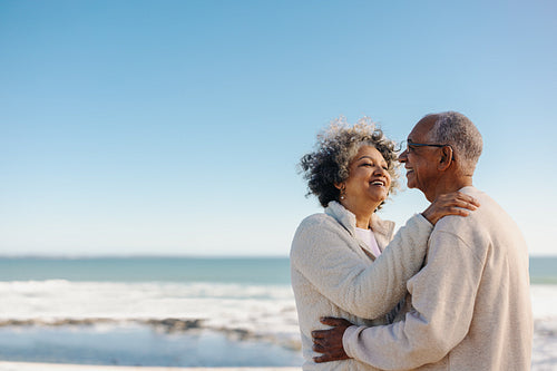 Retired senior couple smiling happily at the beach