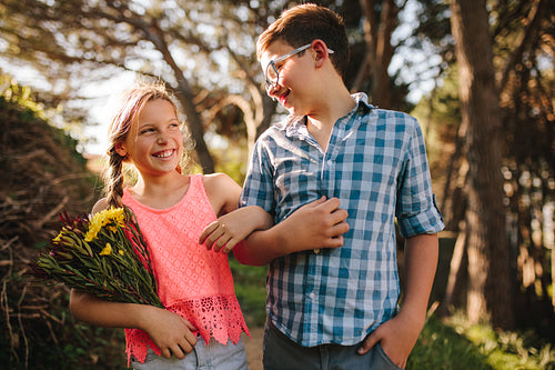 Kids in love walking in park together looking at each other