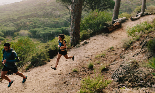 Young couple running on a mountain path
