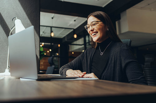 Smiling businesswoman attending an online meeting in a coworking