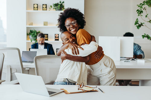 Successful business women celebrating teamwork in creative office environment