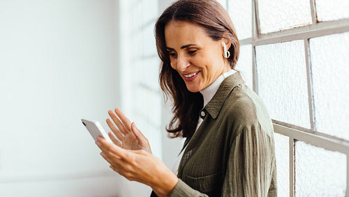 Female professional video calling her business colleagues with a smartphone