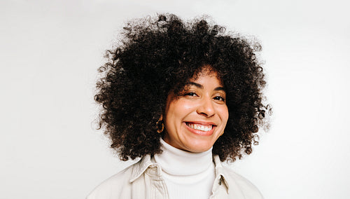 Portrait of a happy woman with curly hair smiling at the camera