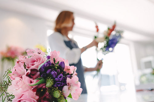 Flower bouquet in front with florist working in background