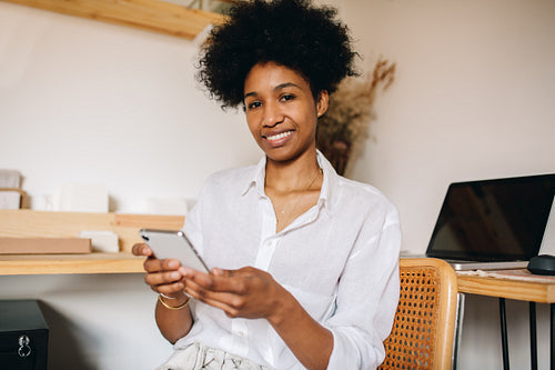 Jewelry designer with her phone in office