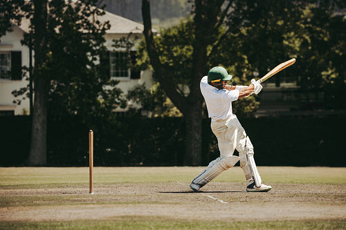 Cricketer in action hitting the ball during an outdoor day match