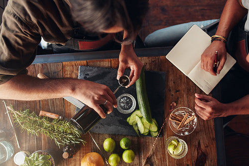 Two barmen creating new cocktail recipe