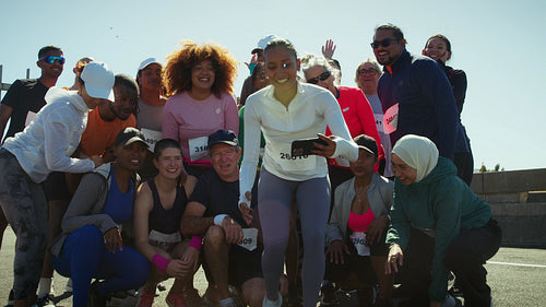 Happy runners pose for group selfie