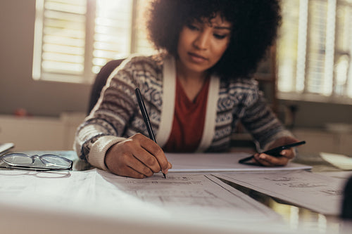 Woman working on building blueprints