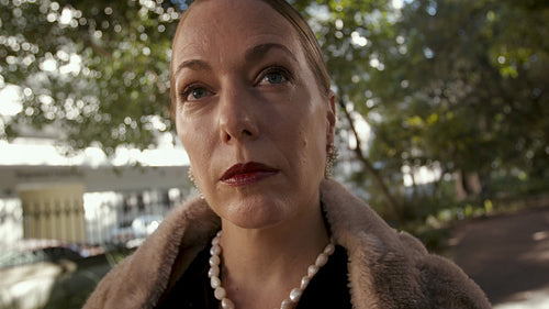 Wealthy woman standing at the park looking away