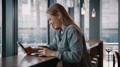 Woman with a mobile phone having coffee at cafe