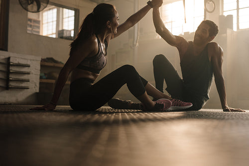 Fitness people high fiving at the gym