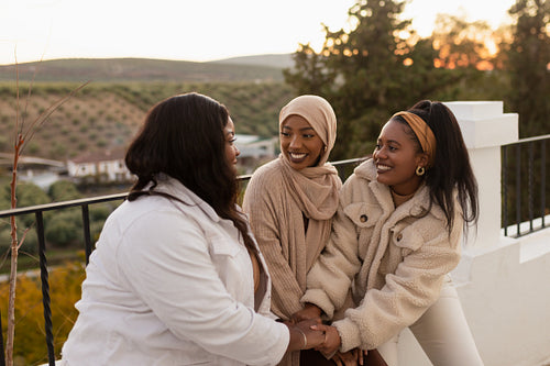 Female friends holding hands together outdoors