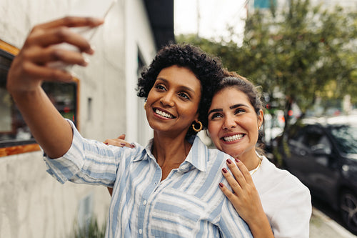 Carefree female friends taking a selfe together outdoors