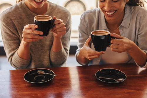 Friends at cafe table drinking coffee
