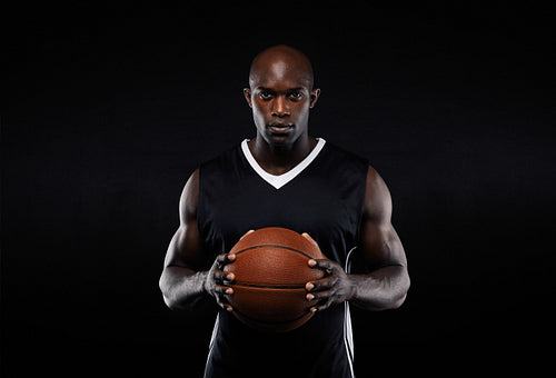 Muscular young male basketball player in uniform