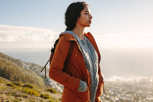 Woman in warm wear standing on a mountain looking away