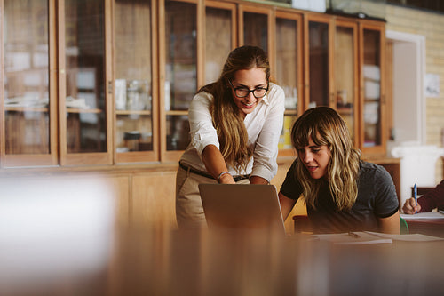 Teacher assisting the female student in study