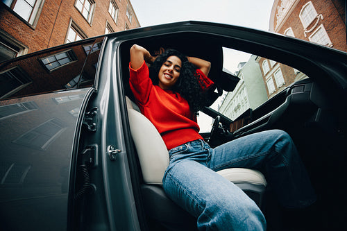 On the road, the car waits as the woman sits during an urban commute