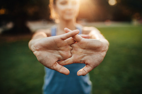 Young woman stretching arms outdoors