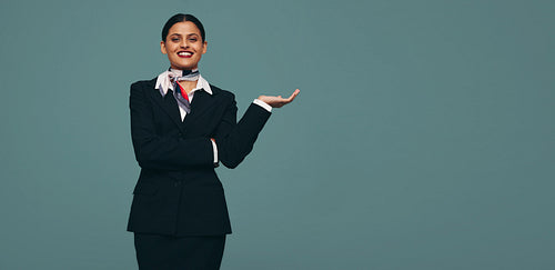 Stewardess holding out her hand in a studio